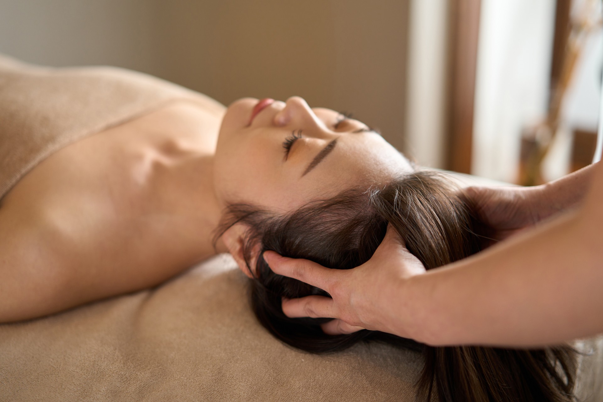 Woman receiving head massage at beauty salon