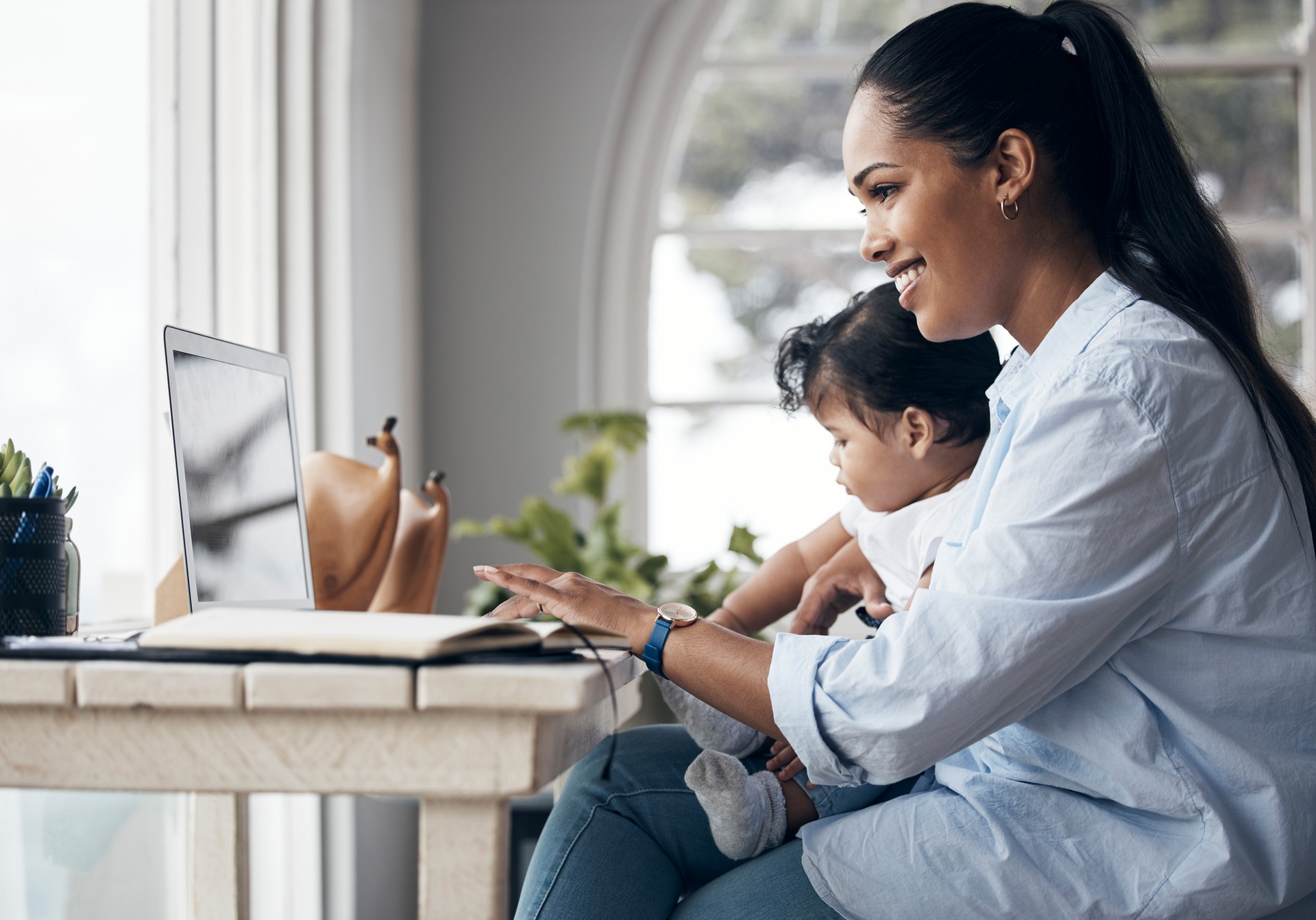 Shot of a young mother caring for her baby girl while working from home